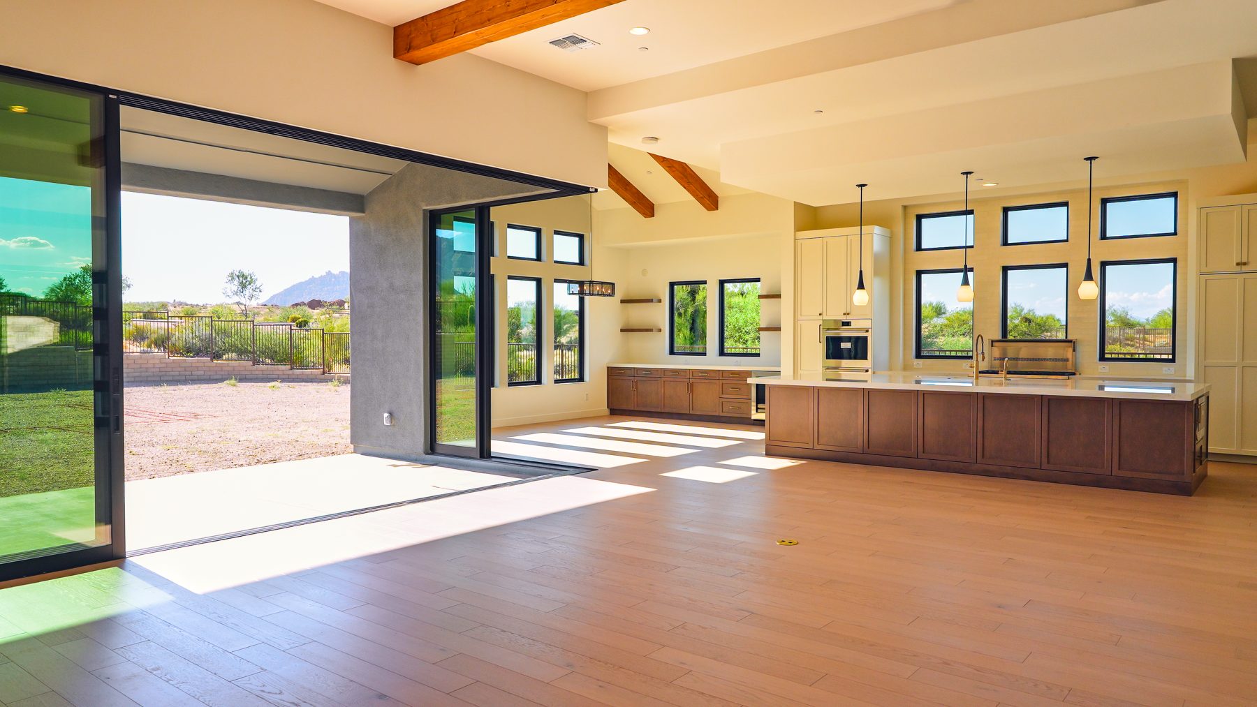 A great room with its sliders open to the desert